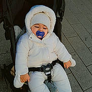Isaak participe au concours pour gagner de l'argent avec cette photo : baby, child, stroller, pacifier, winter_clothing, white_jacket, knit_hat, outdoor, pavement, bundle_up, cold_weather, infant, seated, cute, cozy, baby_gloves, baby_booties, urban, sidewalk, peaceful