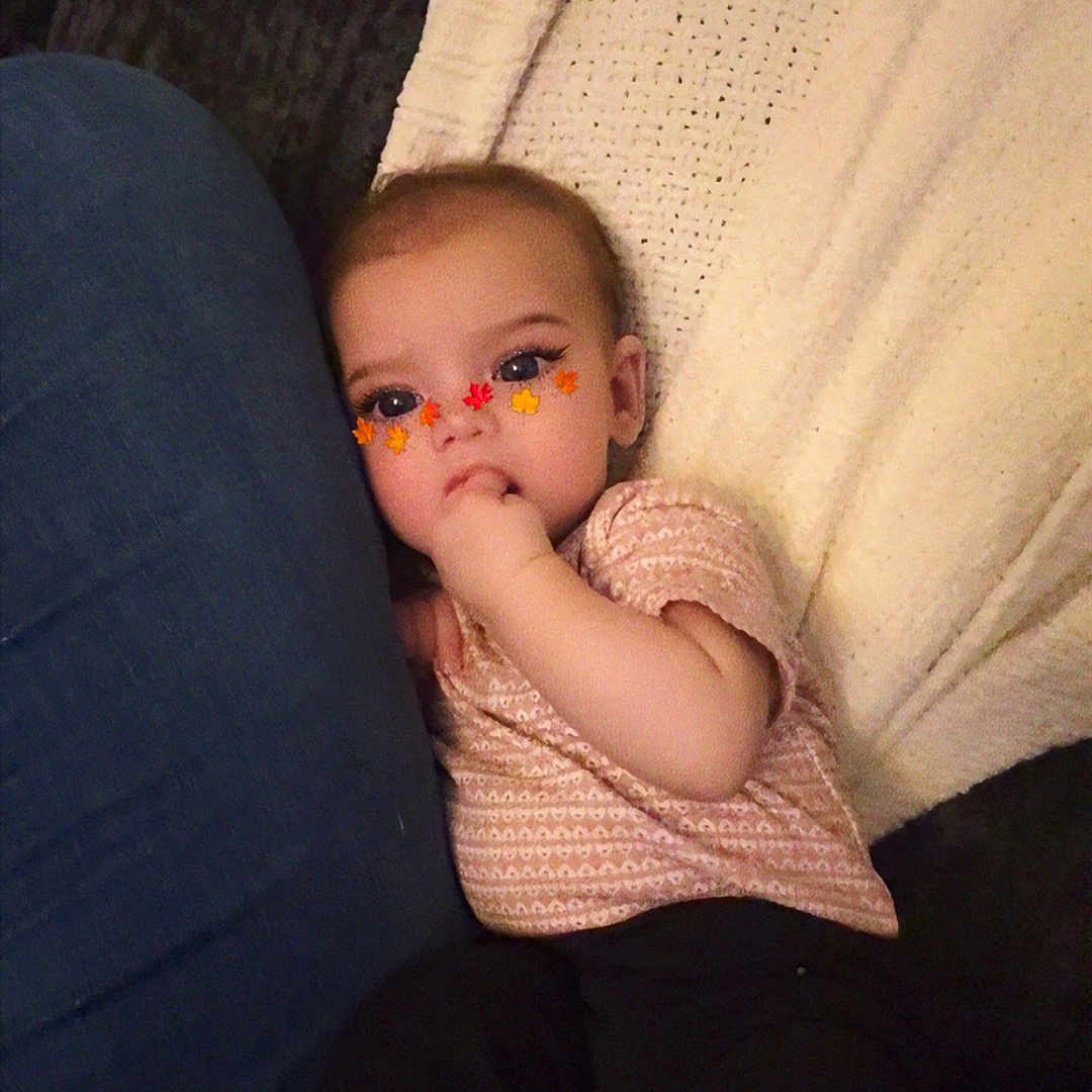 Paislyn joined the competition — help win amazing prizes! baby, child, infant, face, sitting, blanket, couch, leg, hand, finger, clothing, jeans, black_pants, knitwear, autumn, leaf_stickers, cute, indoors, cozy, portrait