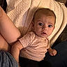 Paislyn is registered to the contest to win money with this photo: baby, infant, child, person, face, eyes, arm, leg, blanket, knit, clothing, pattern, texture, curious, indoor, seated, expression, skin, casual, comfort