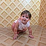 Rylie is registered to the contest to win money with this photo: baby, child, crawling, curly_hair, cute, flooring, hands, happy, indoor, infant, knees, looking_at_camera, patterned_floor, patterned_wall, person, pink_clothing, portrait, smiling, wallpaper, young_child