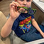 Davis joined the competition — help win amazing prizes! blue_clothing, boy, casual, chair, child, curious, face, glasses, hand, indoor, jeans, looking, marvel, person, short_hair, sitting, superhero, tshirt, wood_floor, young