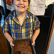 Davis is registered to the contest to win money with this photo: baking, boy, brownies, child, cooking, food, happy, home, indoor, kitchen, pan, paper, person, photo, plaid_shirt, portrait, refrigerator, smile, snack, standing