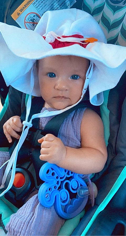 Sophia is registered to the contest to win money with this photo: arm, azure, baby, baby_carriage, baby_products, baby_toddler_clothing, blue, child, costume_hat, electric_blue, fun, hand, happy, headwear, human_body, iris, organ, person, pink, skin