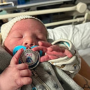 Brayton a rejoint le concours — aidez-le/la à gagner de superbes lots ! baby, blanket, closeup, clothing, cozy, cute, cute_accessory, face, hand, hat, indoor, infant, newborn, pacifier, peaceful, person, sleeping, soft, toddler, zipped_jacket