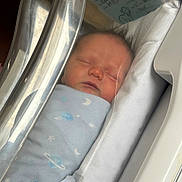 Emerson is registered to the contest to win money with this photo: newborn, baby, swaddled, blanket, hospital, bassinet, sleeping, face, infant, peaceful, blue, plastic_cover, portrait, cute, child, hospital_room, resting, soft_light, young, bed