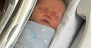 Emerson is registered to the contest to win money with this photo: baby, bassinet, bed, blanket, blue, child, cute, face, hospital, hospital_room, infant, newborn, peaceful, plastic_cover, portrait, resting, sleeping, soft_light, swaddled, young