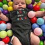 baby, infant, child, onesie, plastic_balls, ball_pit, colorful, play_area, cute, portrait, indoor, clothing, person, skin, face, legs, arms, expression, sitting, soft_lighting