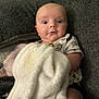 baby, blanket, couch, child, expression, face, furniture, indoor, infant, person, plush, portrait, sitting, surprised, toddler, white_blanket, gray_couch, cute, young_child, cozy