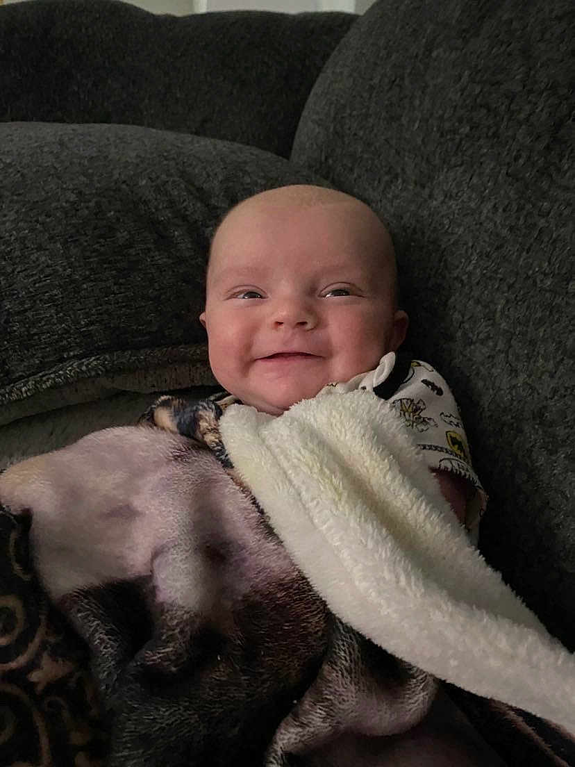 Zachary joined the competition — help win amazing prizes! baby, blanket, smile, couch, cozy, infant, happy, wrapped, comfort, indoor, plush, child, face, portrait, resting, soft, clothing, cute, relaxed, young