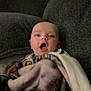 Zachary is registered to the contest to win money with this photo: baby, blanket, couch, infant, face, person, indoor, expression, wrapped, cozy, soft, young, child, home, seated, comfort, furniture, portrait, casual, relaxed
