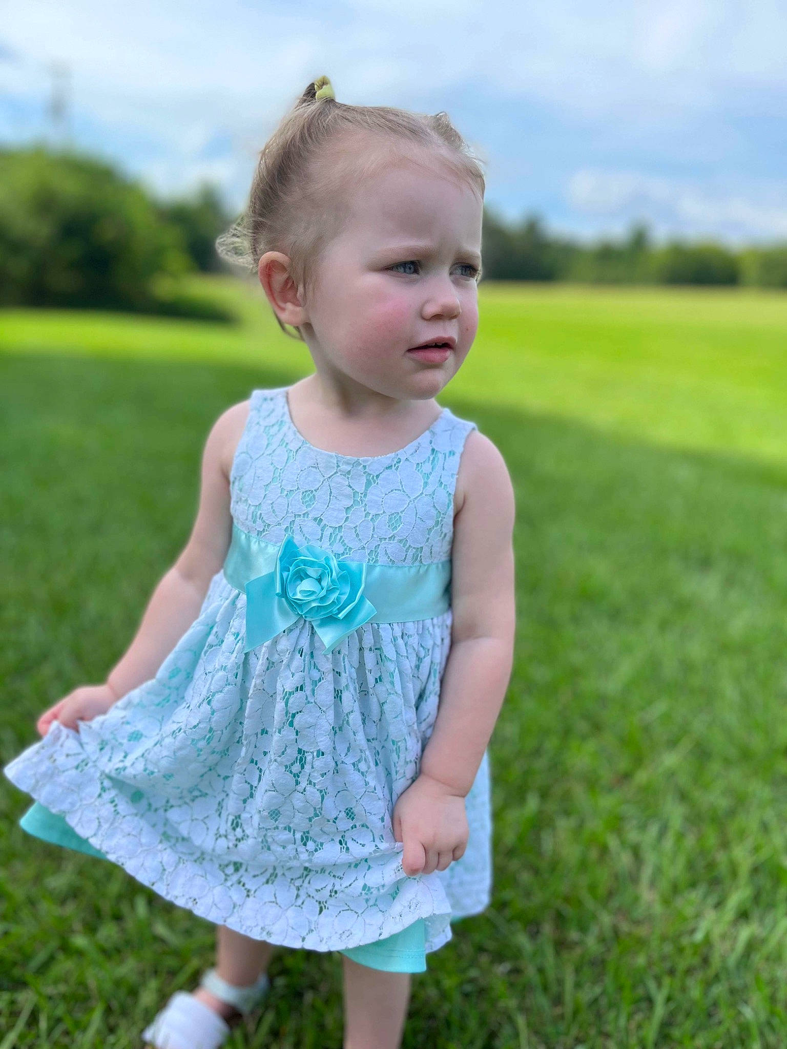Katelyn is registered to the contest to win money with this photo: azure, baby_toddler_clothing, clothing, cloud, day_dress, dress, face, grass, grassland, hair, happy, head, leaf, one_piece_garment, people_in_nature, person, sky, sleeve, standing, summer