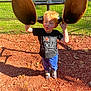 child, playground, outdoor, grass, fence, red_hair, tshirt, shoes, shadow, woodchips, pond, sunny, curious, smudged_face, play_equipment, blue_pants, person, daylight, fun, nature