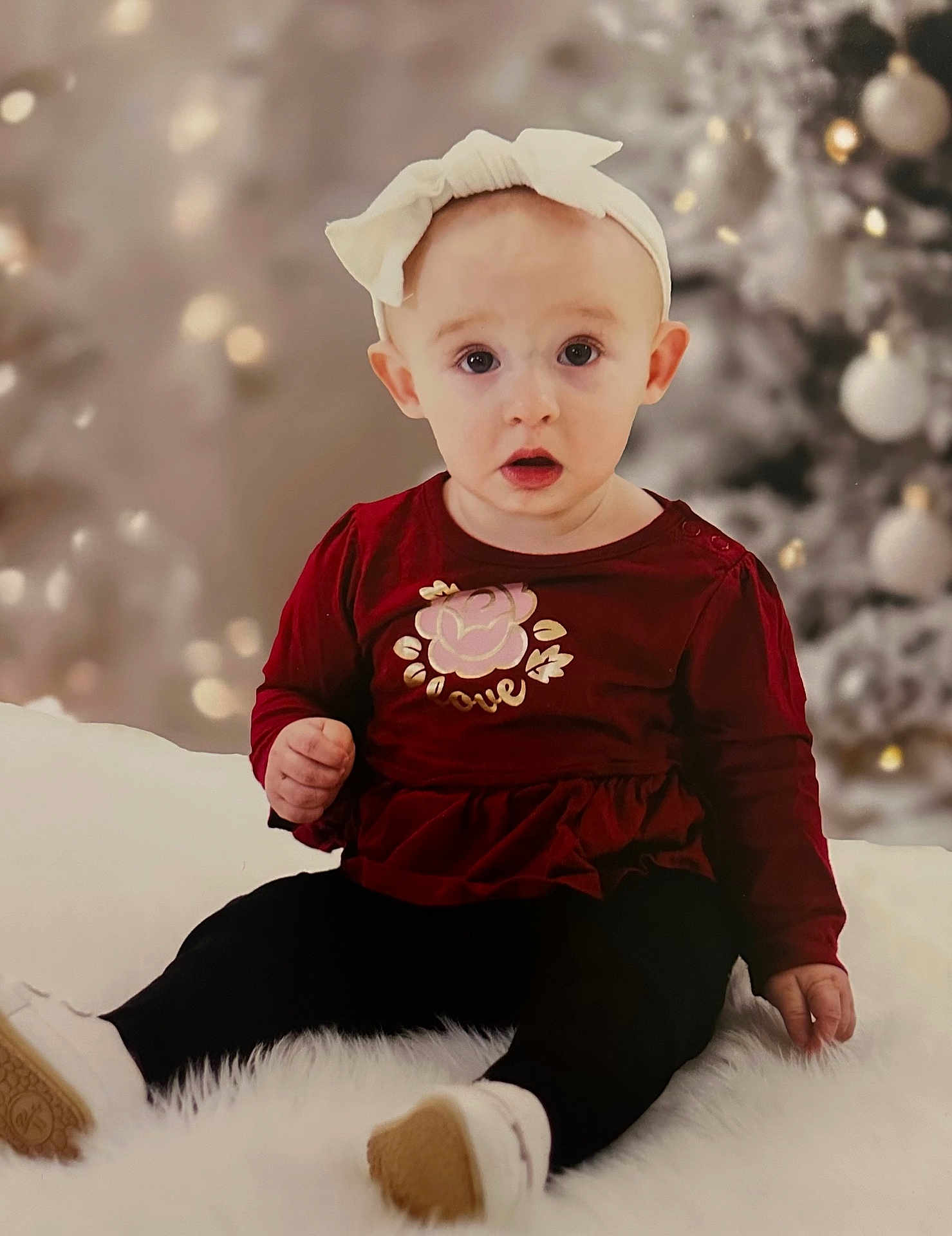 Alyona joined the competition — help win amazing prizes! baby, child, headband, red_clothing, sitting, white_shoes, fluffy_surface, holiday, christmas_tree, decorations, portrait, indoor, cute, wide_eyes, expression, soft_lighting, background_blur, young_child, festive, adorable