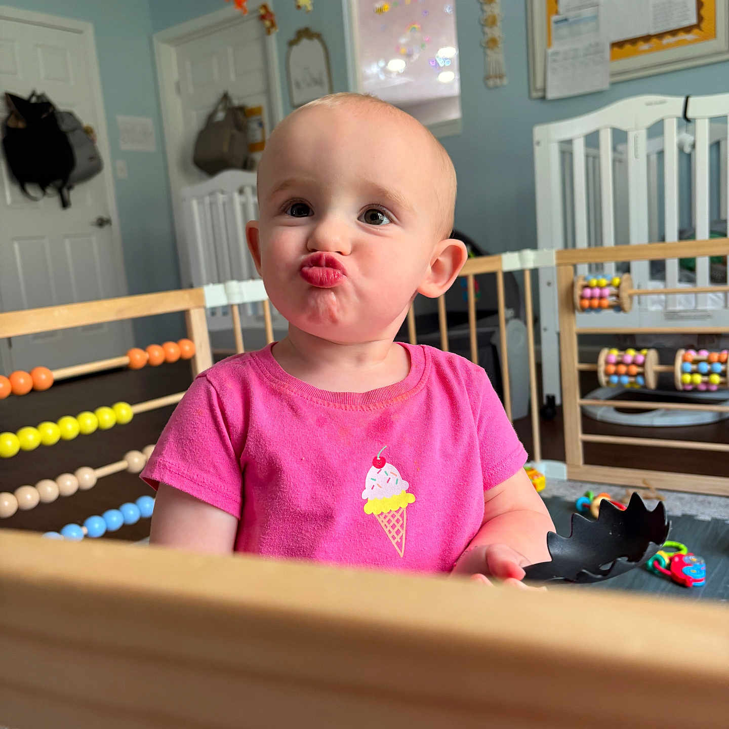 Alyona is registered to the contest to win money with this photo: toddler, child, pink_shirt, playpen, abacus, toy, indoor, cute, pucker_face, baby, colorful, playroom, furniture, wooden_bars, smile, person, young_child, head, portrait, happy