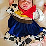 baby, newborn, sleeping, infant, clothing, cow_print, red_scarf, blanket, soft, cute, peaceful, portrait, one_arm_up, foot, hand, face, lying_down, bed, child, adorable