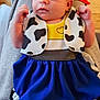baby, infant, child, dress, headband, red_headband, cow_print, blue_dress, person, face, hand, wooden_floor, sitting, clothing, cute, indoor, lap, expression, skin, portrait