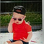 baby, blanket, cap, child, cute, fashion, fun, hat, infant, outdoor, person, plush_toy, portrait, red_shirt, shorts, sitting, summer, sunglasses, sunlight, toy