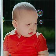 Flavius a rejoint le concours — aidez-le/la à gagner de superbes lots ! baby, boy, bubbles, casual_clothing, child, curious, daylight, expression, face, head_and_shoulders, innocence, nature, orange_shirt, outdoor, portrait, short_hair, skin, summer, toddler, young_child