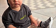 César participe au concours pour gagner de l'argent avec cette photo : toddler, child, cap, blue_cap, striped_shorts, checkered_socks, sneakers, floor, tile_floor, indoor, curious, sitting, casual_clothing, portrait, young_child, person, cute, baby, fashion, blurry_background
