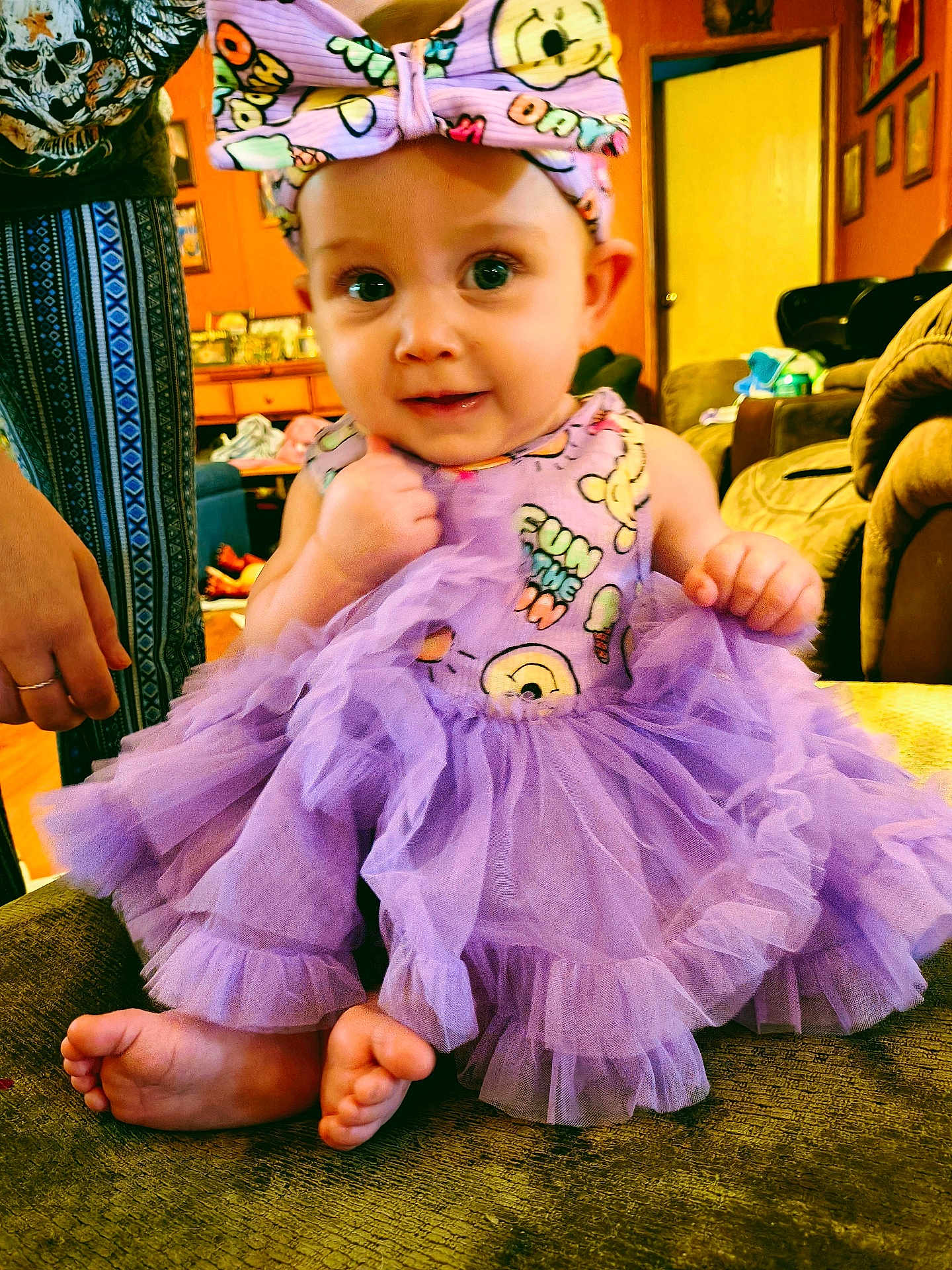 Lillian joined the competition — help win amazing prizes! baby, child, tutu, purple, dress, bow, headband, sitting, feet, living_room, couch, furniture, person, cute, smile, indoors, decor, hand, expression, foot