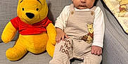 Luca joined the competition — help win amazing prizes! baby, child, plush_toy, winnie_the_pooh, couch, blanket, indoor, cute, infant, clothing, soft_toy, portrait, seated, happy, smile, hand, foot, fabric, furniture, person