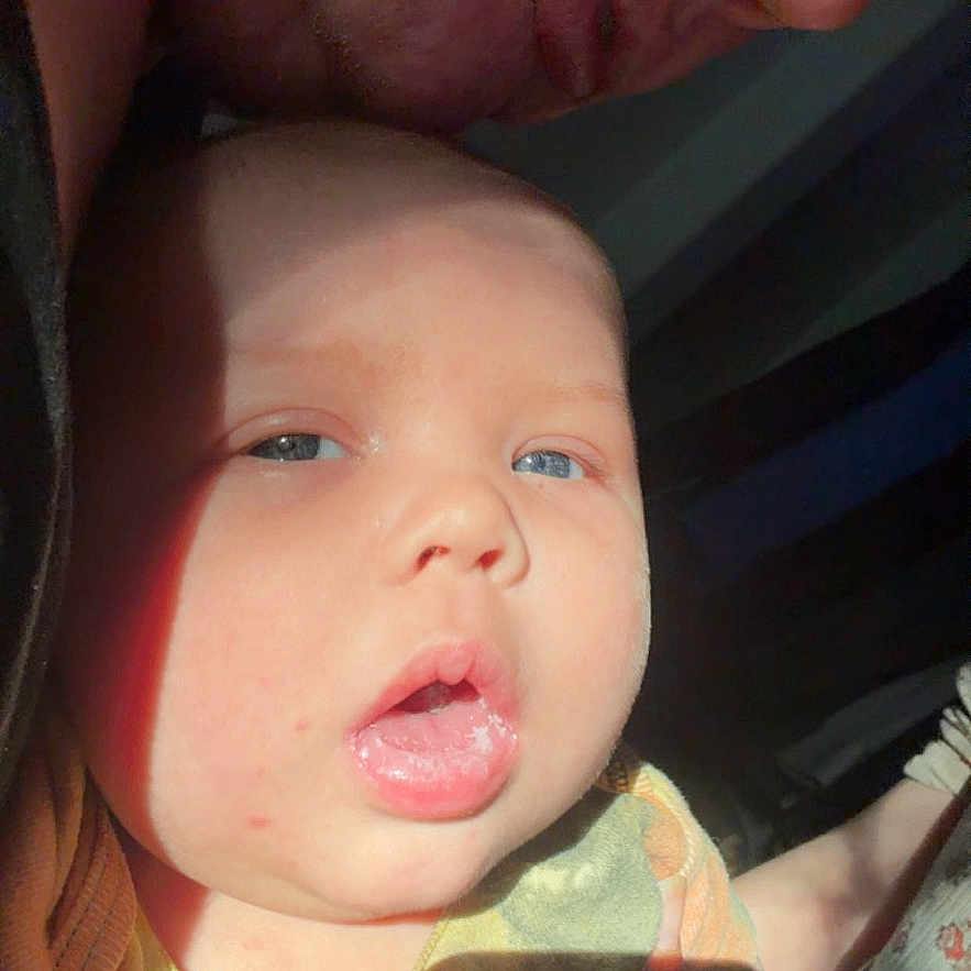 Ezekeil joined the competition — help win amazing prizes! baby, infant, adult, face, close_up, portrait, skin, expression, sunlight, shadow, person, indoor, human, head, mouth, eyes, nose, cheek, phone_screen, mobile_interface
