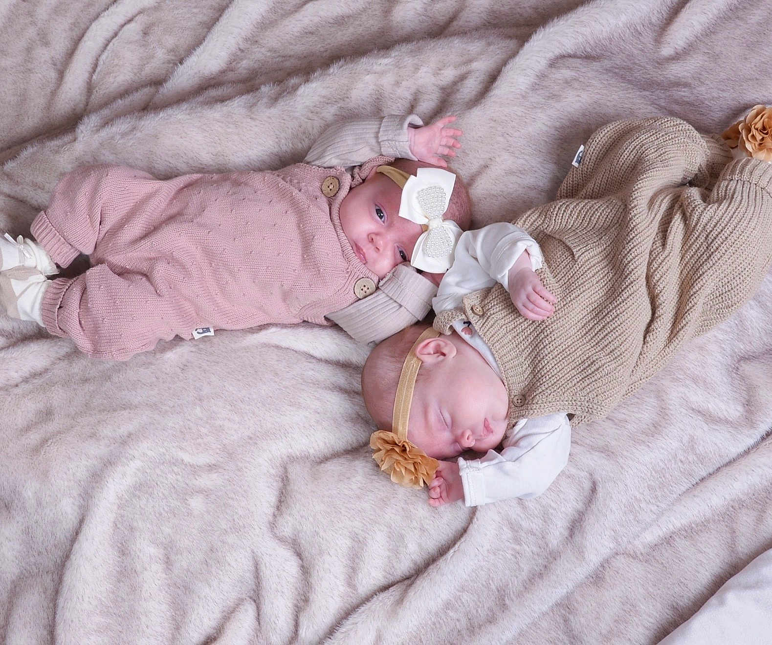 Jojo And Roe is registered to the contest to win money with this photo: baby, infant, sleeping, awake, bow, headband, knitted_clothing, blanket, soft_texture, cute, newborn, lying_down, pink_outfit, beige_outfit, hand, face, portrait, indoor, toddler, peaceful