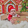 Melody is registered to the contest to win money with this photo: baby, cardboard_box, celebration, child, christmas, cute, decorations, festive, fluffy, gingerbread_house, greenery, holiday, indoors, portrait, red_clothing, santa_hat, seasonal, smiling, snow, tree