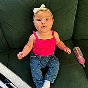 Melody joined the competition — help win amazing prizes! baby, infant, child, pink_tank_top, jeans, heart_pattern, white_socks, bow_headband, green_couch, baby_bottle, drool, sitting, curious_expression, indoors, casual_clothing, portrait, furniture, cute, young_child, person