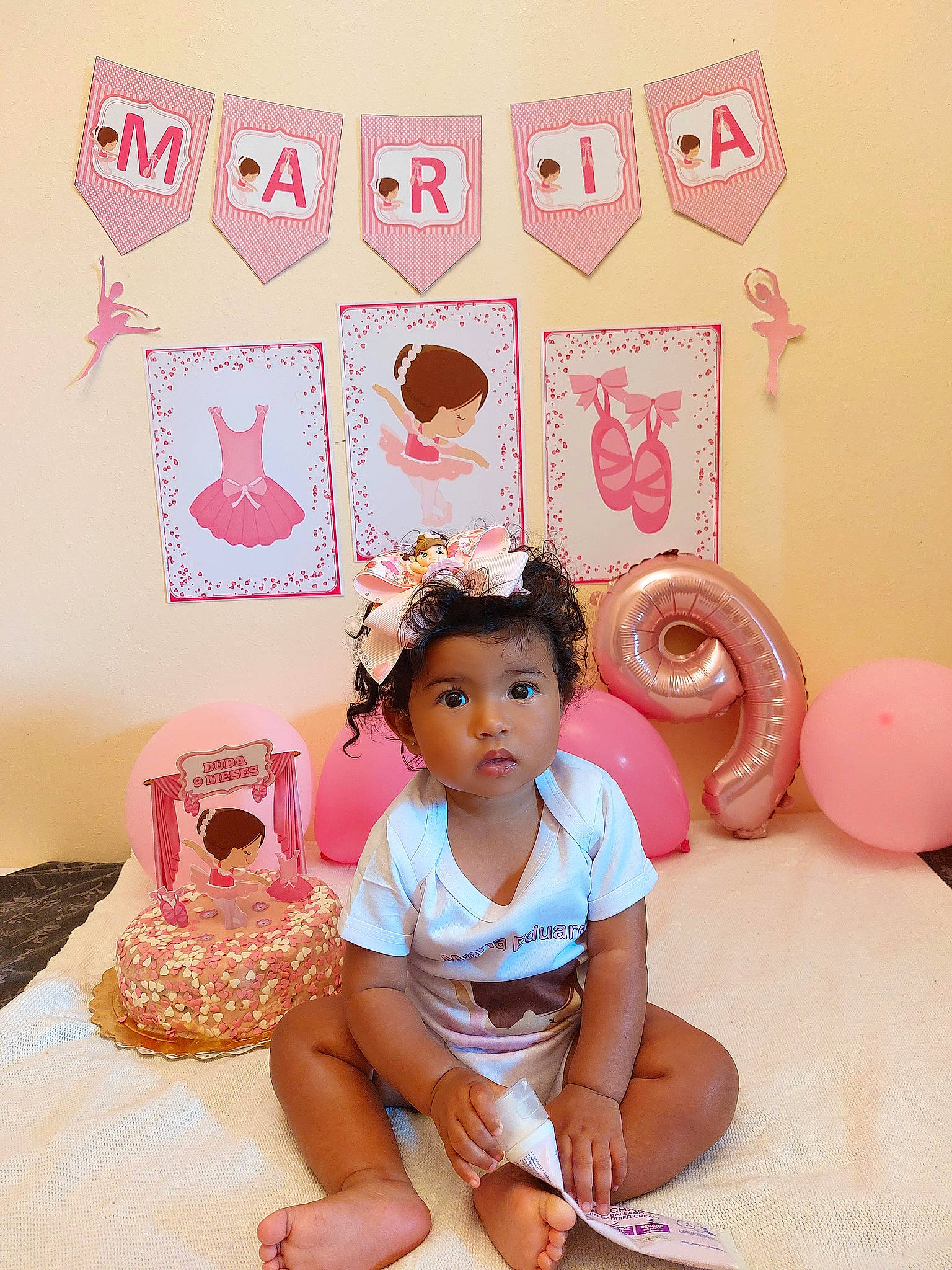 Maria Eduarda participe au concours pour gagner de l'argent avec cette photo : baby_toddler_clothing, child, happy, linens, magenta, mammal, party_supply, pattern, peach, person, pink, product, room, shorts, sitting, sleeve, t_shirt, textile, thigh, toddler