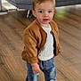 toddler, child, indoor, living_room, wooden_floor, jacket, sweater, jeans, socks, standing, cute, curious, person, furniture, couch, television, window, daylight, home, casual_clothing