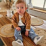 Tommy a rejoint le concours — aidez-le/la à gagner de superbes lots ! toddler, child, sitting, table, wooden_table, jeans, ripped_jeans, jacket, brown_jacket, sneakers, white_sneakers, indoor, vase, dried_flowers, placemats, window, blinds, curious, casual_clothing, home_interior
