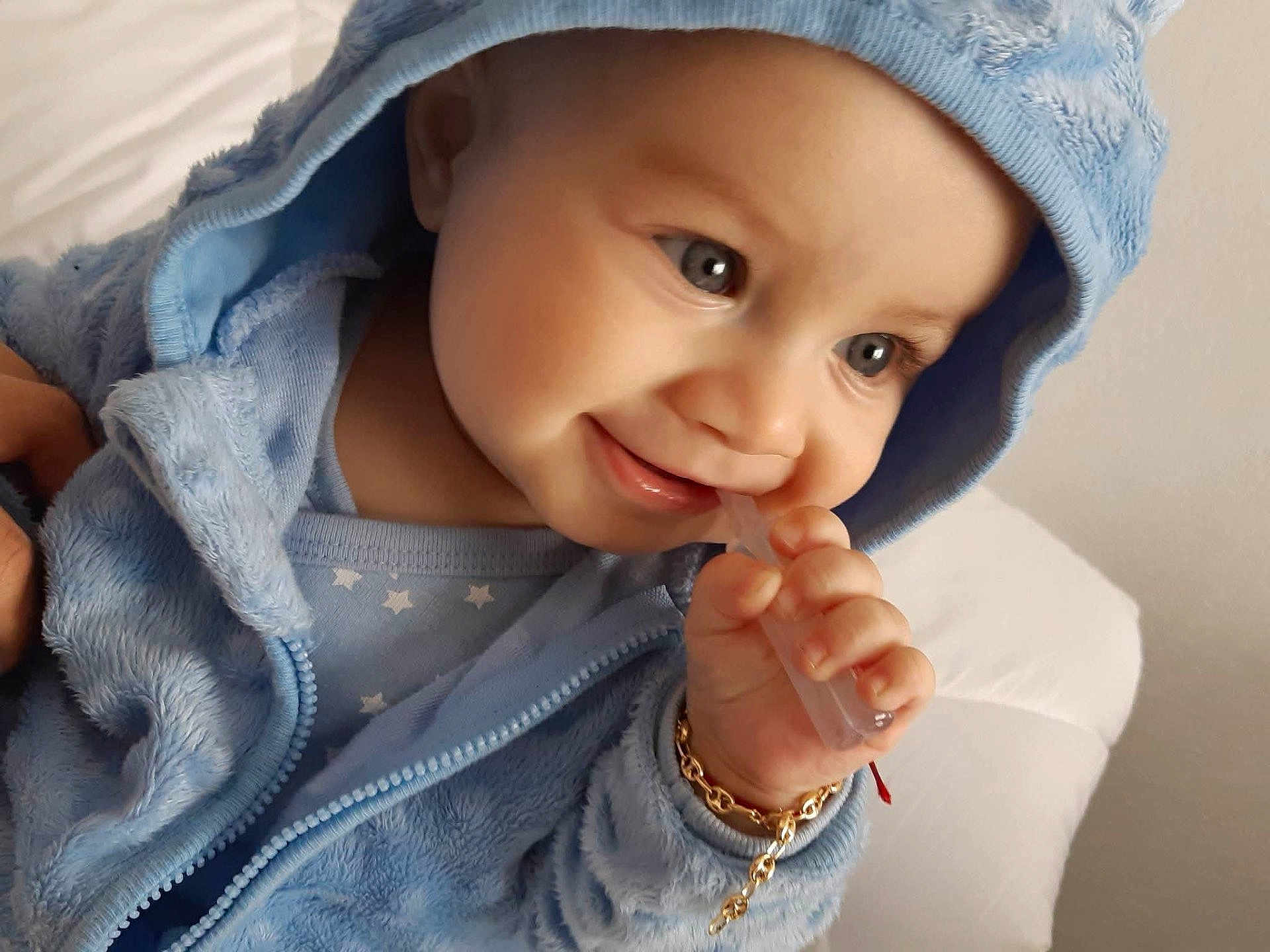 Leonardo a rejoint le concours — aidez-le/la à gagner de superbes lots ! baby, child, blue_jacket, hood, closeup, face, hand, bracelet, smile, cute, infant, indoors, skin, eyes, clothing, portrait, happy, young, person, soft_texture