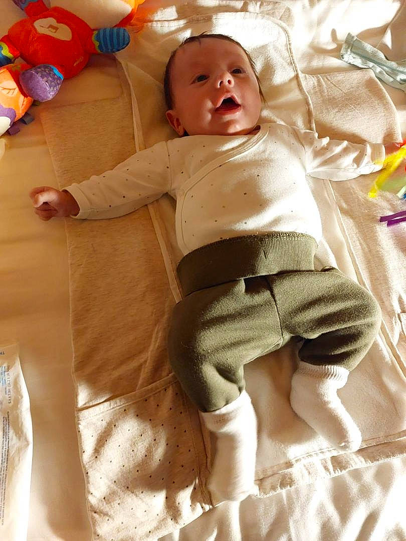 Soën participe au concours pour gagner de l'argent avec cette photo : abdomen, arm, baby, baby_playing_with_toys, baby_toddler_clothing, comfort, eye, face, finger, happy, head, human_body, joint, leg, linens, person, skin, toddler, toy, trunk