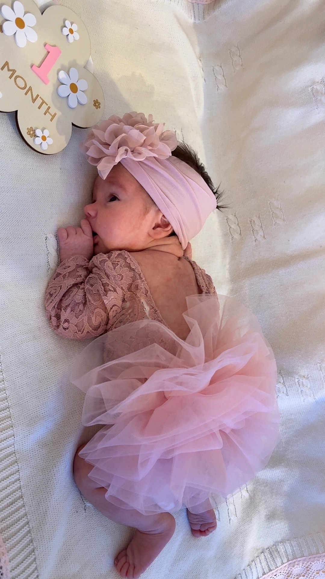 Lyna Beaudier participe au concours pour gagner de l'argent avec cette photo : baby, infant, newborn, pink, lace, tutu, headband, flower, blanket, soft, cute, sucking_thumb, milestone, wooden_sign, one_month, lying_down, indoors, portrait, child, adorable