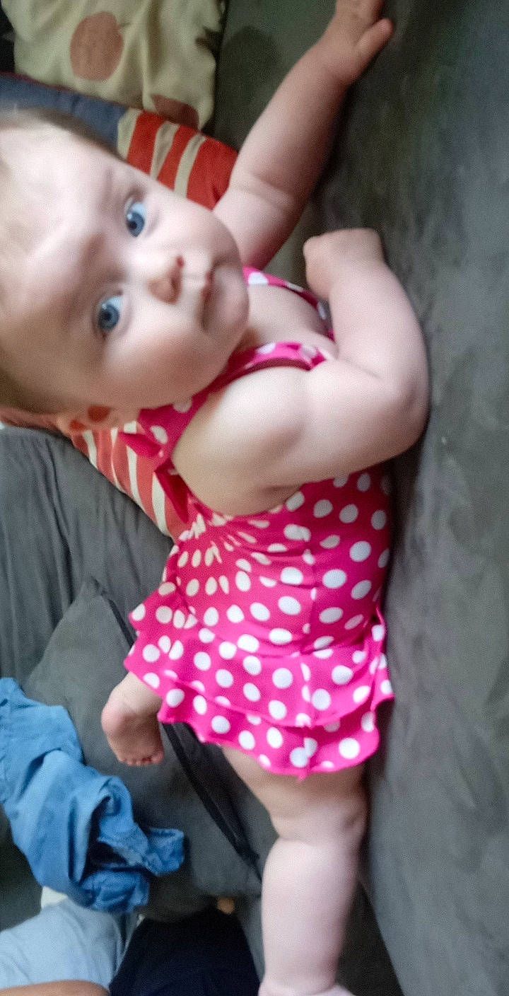 Amaya participe au concours pour gagner de l'argent avec cette photo : baby, baby_toddler_clothing, chest, dress, eye, facial_expression, finger, gesture, hand, happy, human_body, lip, mouth, neck, nose, person, pink, skin, stomach, thigh