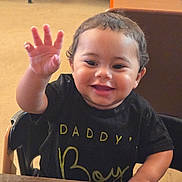 Kaiden joined the competition — help win amazing prizes! toddler, child, smiling, waving, black_shirt, high_chair, indoor, wooden_table, happy, person, baby, face, cute, short_hair, sitting, table, furniture, casual_clothing, bright, expression