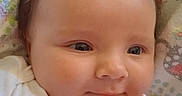Zoey joined the competition — help win amazing prizes! baby, infant, pacifier, bow, hair_accessory, blanket, patterned_blanket, white_clothing, closeup, face, skin, child, cute, smiling, lying_down, young_child, indoors, soft_light, peaceful, adorable