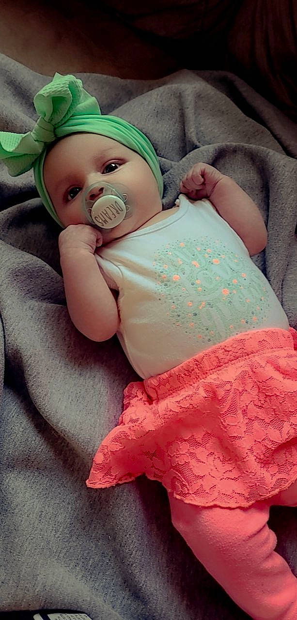 Briella is registered to the contest to win money with this photo: arm, baby, baby_sleeping, baby_toddler_clothing, comfort, eye, finger, hand, head, headgear, human_body, joint, leg, mouth, organ, person, pink, skin, stomach, textile