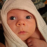 Brody is registered to the contest to win money with this photo: baby, infant, towel, face, eyes, skin, hand, newborn, portrait, closeup, cute, wrapped, soft, expression, curious, child, indoors, person, head, blanket