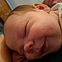 Brody is registered to the contest to win money with this photo: baby, blanket, close_up, clothing, comfort, cozy, ear, face, head, indoors, infant, newborn, peaceful, person, portrait, rest, skin, sleeping, smile, young_child
