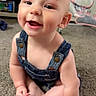baby, child, infant, denim_overalls, smile, happy, sitting, carpet, indoor, cute, face, skin, hand, foot, person, expression, young, home, furniture, toy