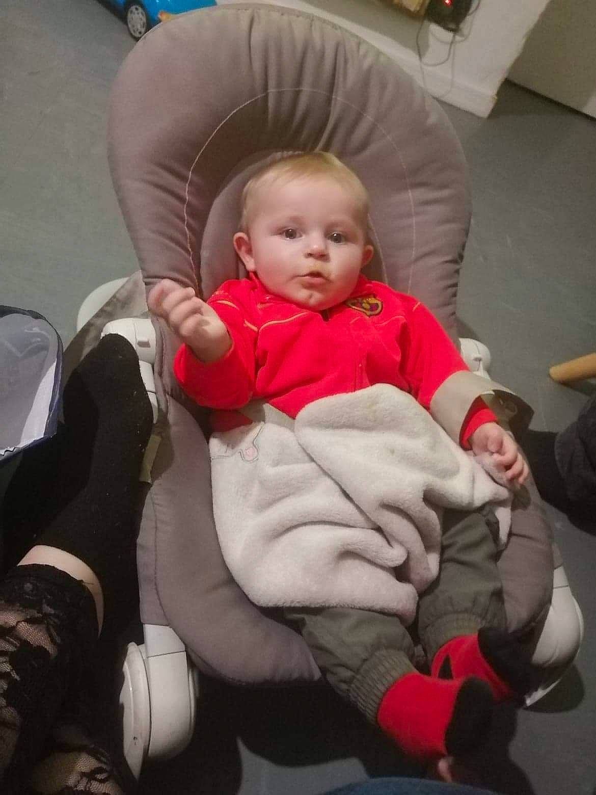 James participe au concours pour gagner de l'argent avec cette photo : baby, baby_carriage, baby_toddler_clothing, cheek, child, comfort, couch, flooring, fun, human_leg, knee, lap, leg, mammal, person, product, sitting, skin, sock, thigh