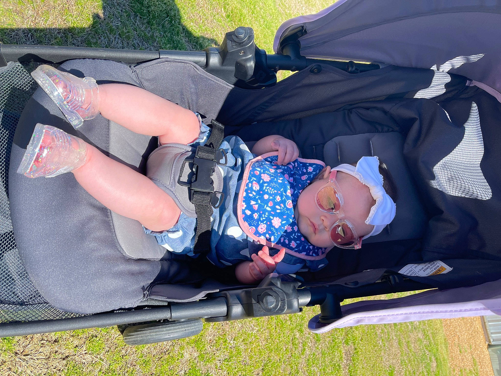 Paisley is registered to the contest to win money with this photo: auto_part, baby, baby_carriage, baby_products, baby_toddler_clothing, child, comfort, fun, grass, lap, leisure, person, recreation, smile, toddler, tree, vacation, wheel