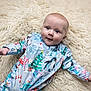 baby, infant, onesie, christmas, holiday, penguin, snowman, candy_cane, christmas_tree, fluffy_rug, soft_texture, lying_down, cute, child, face, smiling, blue_eyes, winter, festive, cozy