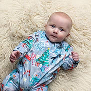 Elliott joined the competition — help win amazing prizes! baby, infant, pajamas, christmas, holiday, penguin, snowman, candy_cane, christmas_tree, gift, fluffy_rug, soft_texture, cute, smiling, lying_down, indoors, child, face, hands, winter_clothing