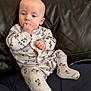 Elliott joined the competition — help win amazing prizes! baby, child, infant, mickey_mouse, onesie, pajamas, couch, leather, sitting, hand_in_mouth, curious, indoor, person, clothing, cute, young, home, furniture, relaxed, portrait