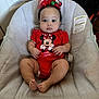 Diamond is registered to the contest to win money with this photo: baby, infant, child, onesie, minnie_mouse, red_clothing, headband, holiday, ornaments, baby_seat, cushion, indoors, door, curious, sitting, feet, hands, face, expression, cute