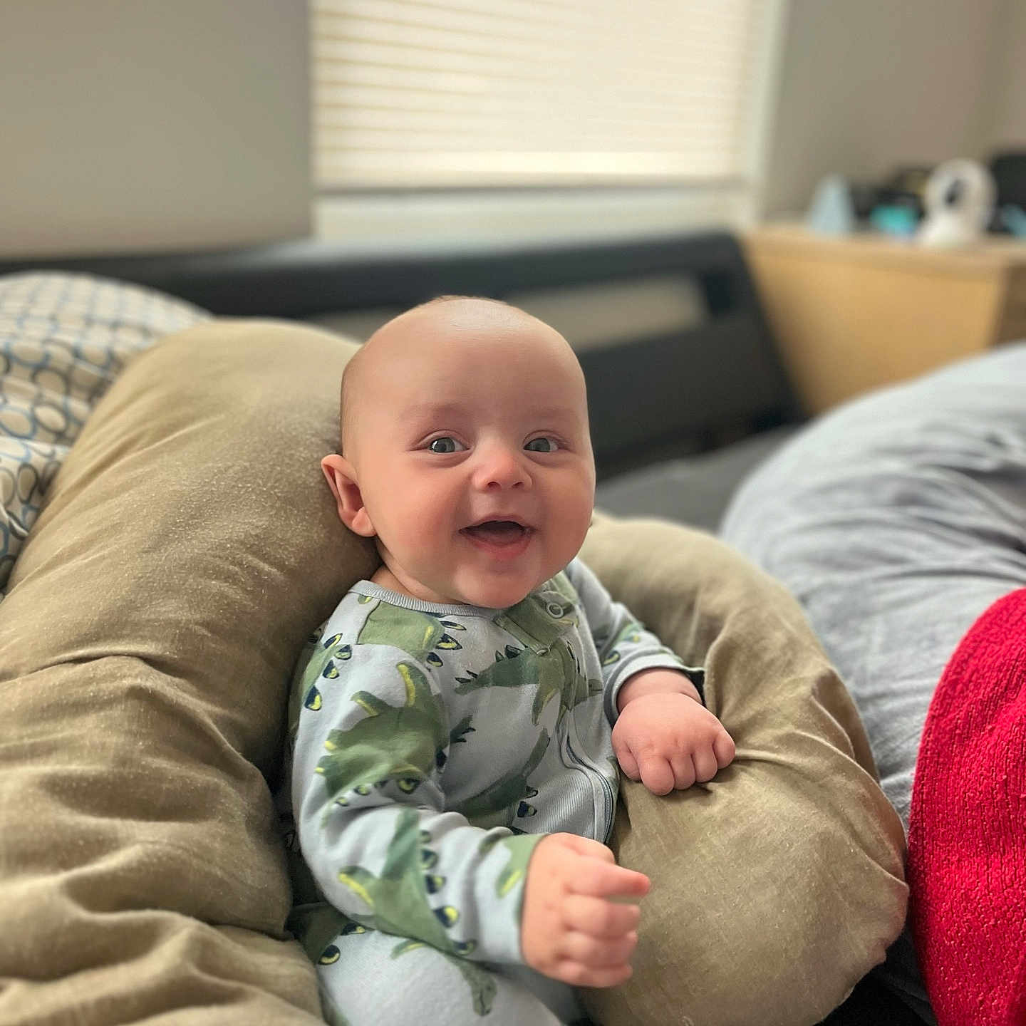 Lawton joined the competition — help win amazing prizes! baby, bed, blanket, child, comfort, cozy, cushion, cute, dinosaur_pajamas, furniture, happy, indoor, infant, person, portrait, rest, sleepwear, smile, soft_light, window_blinds