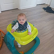 Lawton joined the competition — help win amazing prizes! baby, walker, floor, blue_eyes, smile, infant, toy, clothing, bib, indoor, wooden_floor, door, white_wall, child, play, happy, person, sitting, cute, young